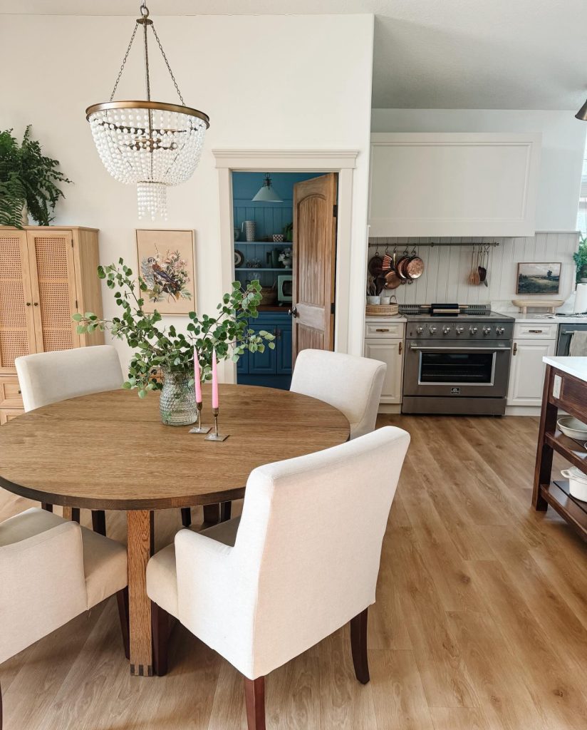 a dining room with round ikea walnut table, walls painted simply white by Benjamin Moore trim natural tan by Sherwin Williams